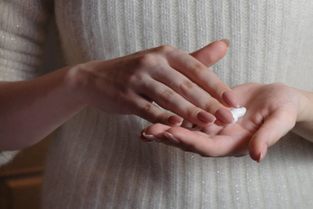 girl puts nourishing cream on her handsの写真素材
