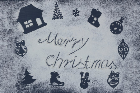 Merry Christmas made from flour and prints of New Year decorations on the table.の写真素材