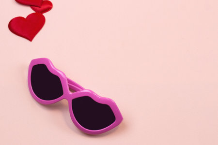 pink glasses and hearts on a light background. Copy spaceの写真素材