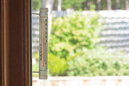 An air temperature of 40 degrees is shown by a thermometer. Summer heat.の写真素材