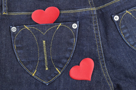 Red heart in jeans pocket. View from above