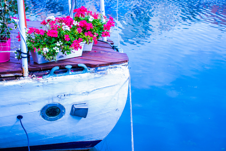 The nose of the boat on the water is decorated with flowers.の写真素材