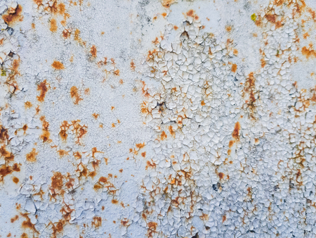 White paint peeling off on rusty metal.の写真素材