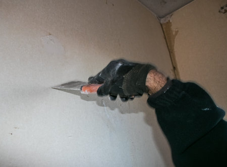 Repair work in the house. Closing holes in the wall with putty.の写真素材