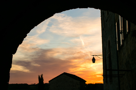 Sunset in a medieval European city is visible through the arch of the city .. France.Villageの写真素材