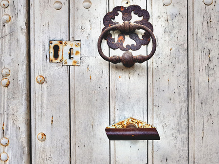 An old wooden door with rusty iron accessories.の写真素材