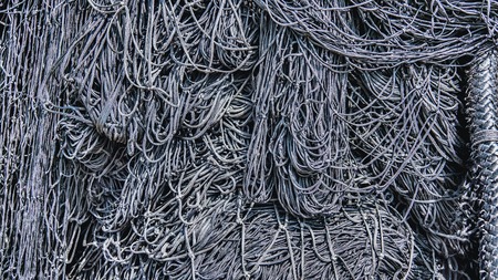 Black fishing net closeup, old and used, on the quayの写真素材