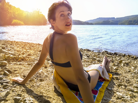 Attractive woman in bikini at the shore. Summer lifestyle portraitの写真素材