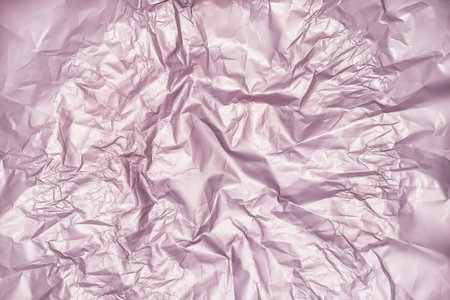 Gentle pink background from the texture of crumpled satin paper.