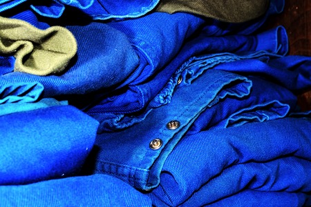 Stacks of folded work clothes in blue.の写真素材
