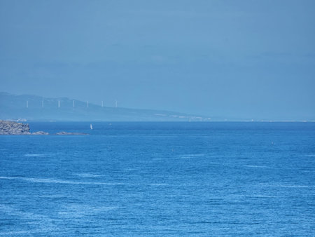 Horizon in the sea with rocks away in blue haze