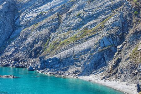 The azure sea approaches the rocky coast of the bay.の写真素材