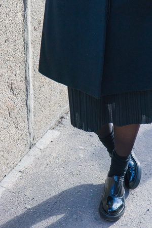 Girl walking in fashionable black shoes on the street in cold dayの写真素材