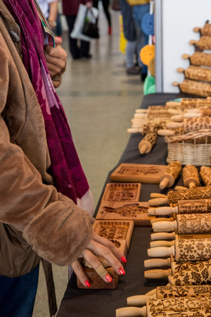 Women choosing and  buying wooden  Rolling Pins with Christmas Symbols for Homemade Christmas...