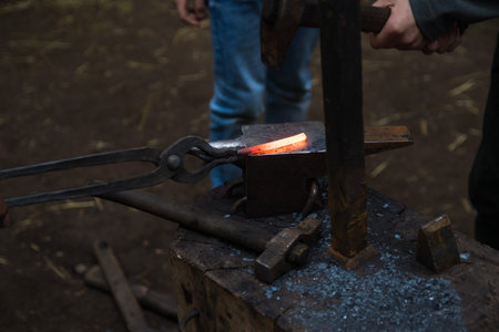 Blacksmith working metal with hammer