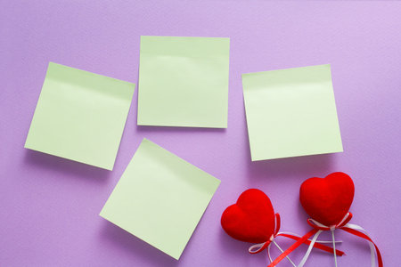 light blue stickers on a purple wall for Valentine's Day scrapbook, two red hearts, Postcard with place for textの写真素材