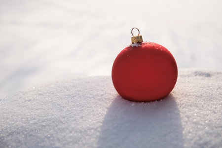 Red christmas ball on snow background. Christmas and New Year conceptの写真素材