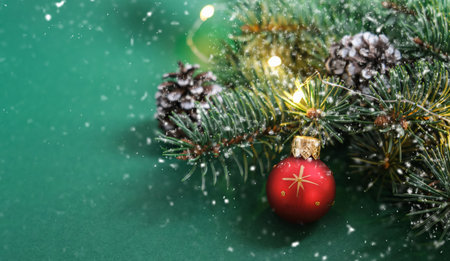 Christmas red ball, Christmas tree, cones and defocused lights on green background. Snow.Concept: Christmas and New Year, winter holiday theme. Selective focus. Copy space for textの写真素材