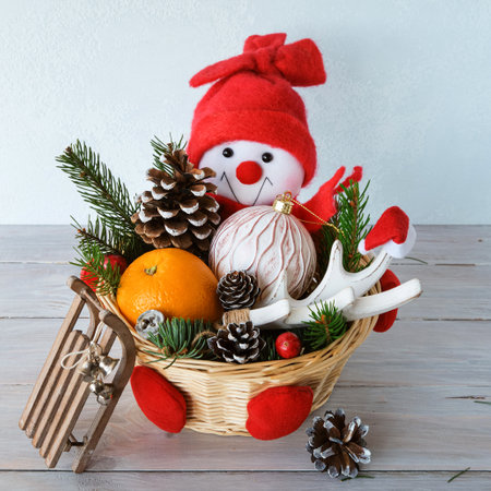 Decorative basket with Christmas decorations. Funny and cute Snowman with New Year's gifts. Winter and Christmas concept. Close-up. Square.の写真素材