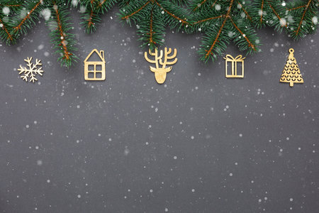 Flat lay composition with Christmas fir tree branches and festive decor wooden handmade gold color on dark gray background. Christmas frame, greeting card template, mockup. Flat lay, top view, copy spaceの写真素材
