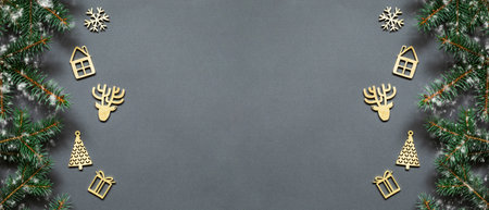 Flat lay composition with Christmas fir tree branches and festive decor wooden handmade gold color on dark gray background. Christmas frame, greeting card template, banner mockup. Flat lay, top view, copy spaceの写真素材