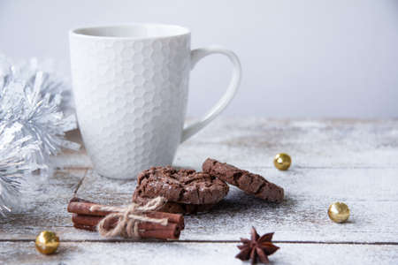Christmas wooden table with white cup, cookies and tinselの写真素材