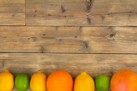 Wooden background with citrus fruits. Copy space. Flat lay.