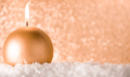 A small Golden candle on a shiny gold background. The idea of celebrationの写真素材