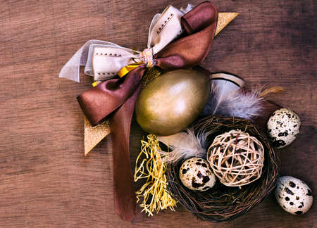 Easter eggs composition in brown tones with bow and feathersの写真素材