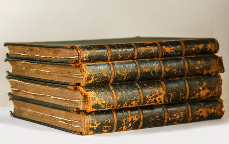 Antique books with frayed pages pile on white background