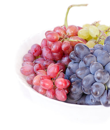 grapes of different varieties - pink black and white on a white background