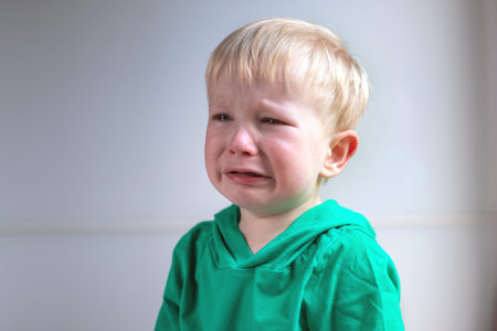 portrait of a crying child on a light background. close up.