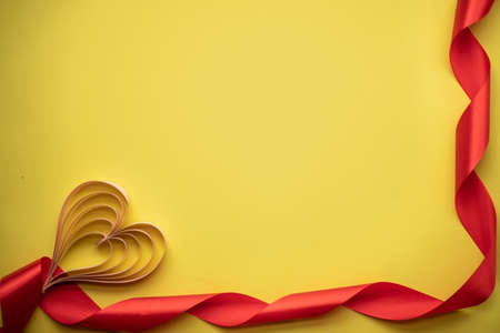 paper heart on a yellow background with a red ribbon. place for text.の写真素材