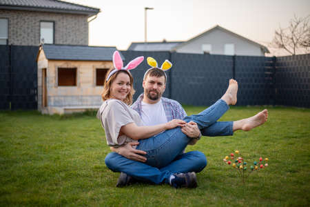 family couple wearing bunny ears celebrating easter. husband holding his wife in his arms.の写真素材