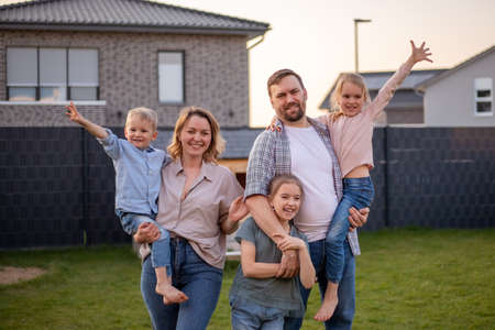 family portrait. happy family mom, dad, daughter, son are relaxing and having fun in the backyard of their house.の写真素材