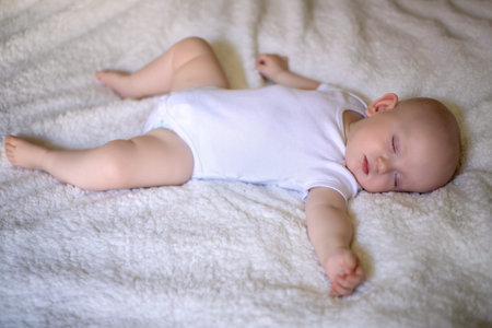little baby sleeping in a snow-white bed.