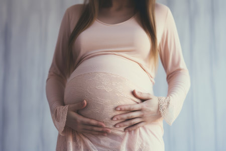 Image of pregnant woman touching her belly with hands.の素材