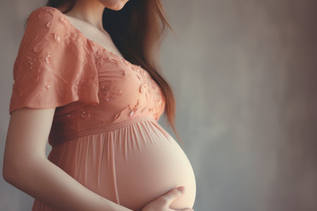 Image of pregnant woman touching her belly with hands.の素材