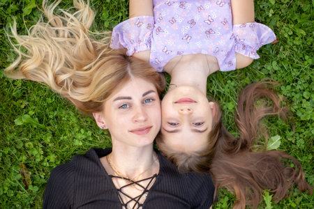 Mother and daughter embracing on grass