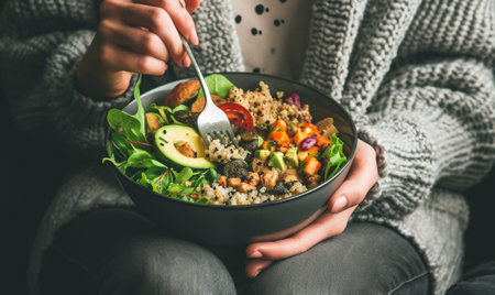 Woman holding a vegetable salad bowl near window lightの素材
