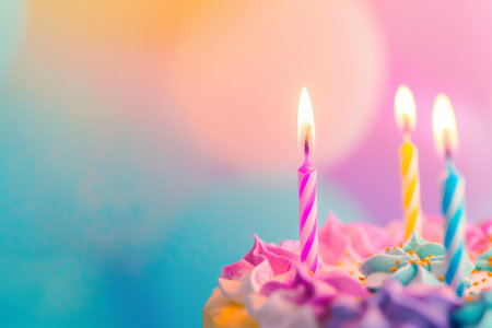 Burning candles on a festive cake with bright colors.の素材