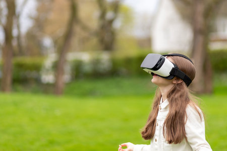 Girl in virtual reality headset looking up in a park.