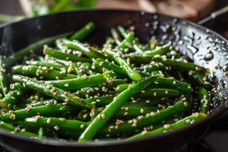 Green beans with sesame in pan, steam visible.の素材