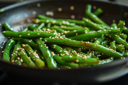 Green beans with sesame in pan, steam visible.の素材