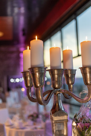 Elegant candlelit arrangement enhances evening ambiance at a stylish event venue overlooking a sunsetの写真素材