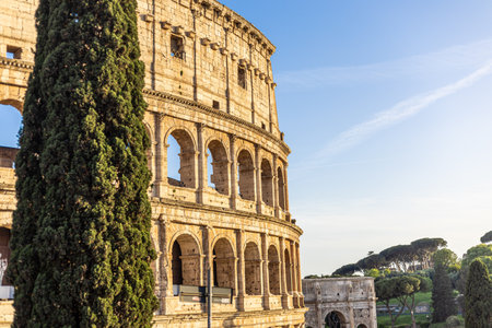 Ancient Roman architecture stands tall under the sunset sky inviting visitors at the Colosseum in Italys historic heartの写真素材