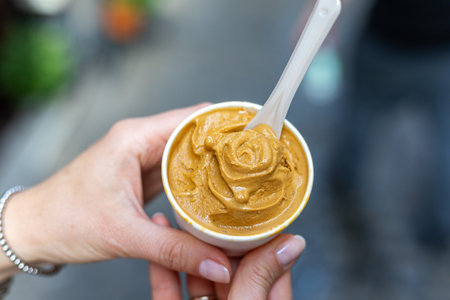 Delicious creamy dessert served in a cup at a bustling market during a warm afternoonの写真素材