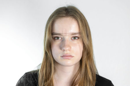 Young woman prepares for permanent makeup eyebrow procedure in a beauty studio