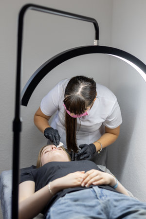 Beauty treatment taking place in a modern salon with a client receiving facial careの写真素材