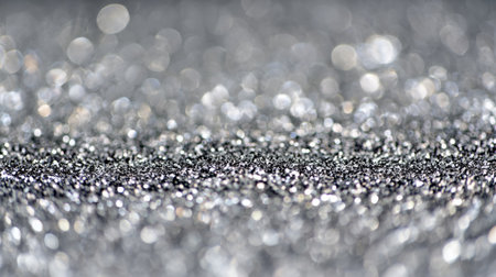 Shimmering silver glitter creates a stunning backdrop with sparkling reflections in soft focus lightingの素材